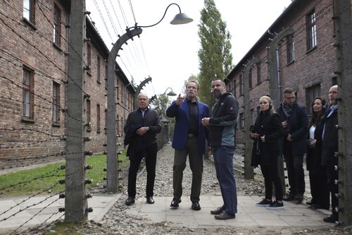 Arnold Schwarzenegger, centre, and Simon Bergson, chairman of The Auschwitz Jewish Center Foundation, left, visit Auschwitz - Birkenau Nazi German death camp in Oswiecim, Poland, Wednesday, Sept. 28, 2022. 