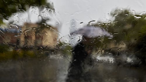 A resident takes cover under an umbrella as heavy rain hits Sydney on October 5, 2022.