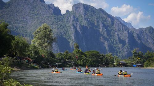 Tourists kayak the Namsong River in Vang Vieng, Laos.