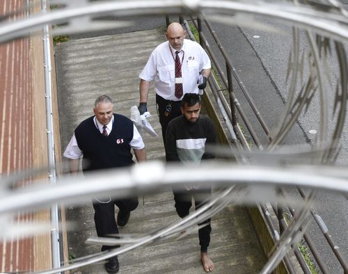 Lyle Morrison is escorted by court security out of the Magistrates court in Adelaide last month. 