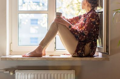 Woman sitting on window sill