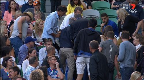 The crowd gathers around coach Nigel Sears after he collapsed.