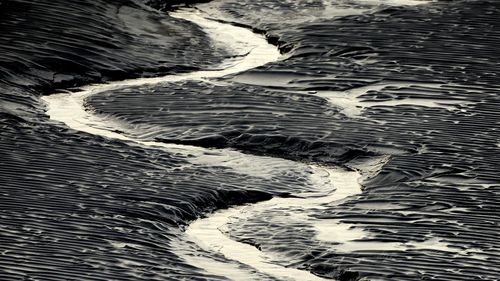 A channel flows through the mud flats along the Seward Highway and Turnagain Arm in Alaska on October 25, 2014. 