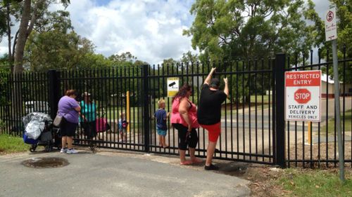 Parents anxiously await news outside of the school in Mabel Park. (9NEWS)