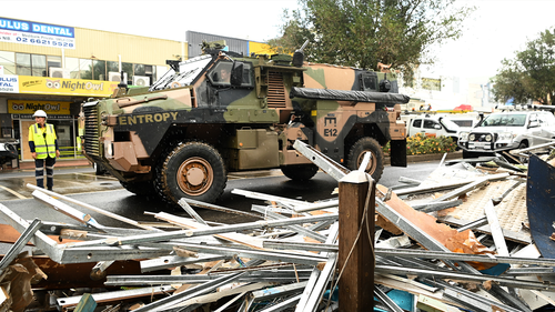 An army vehicle drives past debris in the flood-affected city centre on March 29, 2022 in Lismore, Australia. Evacuation orders have been issued for towns across the NSW Northern Rivers region, with flash flooding expected.