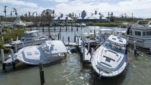 Boaters look over boats are stacked up at the Port Sanibel Marina after Hurricane Ian ran through the area Thursday, Sept. 29, 2022, in Fort Myers, Fla. (AP Photo/Steve Helber)