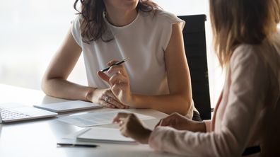 Two diverse serious businesswomen discussing business project working together in office, serious female advisor and client talking at meeting, focused executive colleagues brainstorm sharing ideas (Two diverse serious businesswomen discussing busines