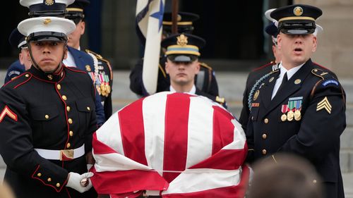 A joint services body bearer team carries the flag-draped casket of former Vice President Dick Cheney out of the Washington National Cathedral.