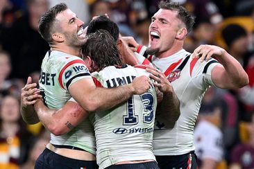 Roosters players celebrate a Connor Watson try.