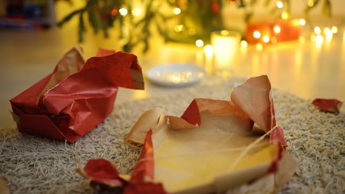 Empty gift wrapping under the tree on Christmas morning. A plate of cookie crumbs and an empty milk glass after a night visit from Santa Claus. Santa delivered gifts under the Christmas tree.