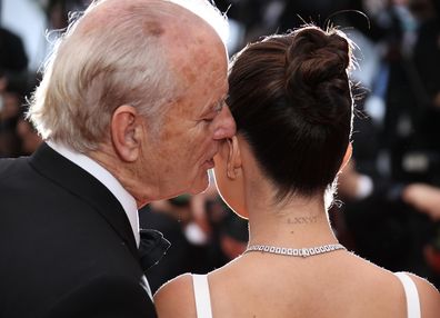 Bill Murray whispers into Selena Gomez's ear.