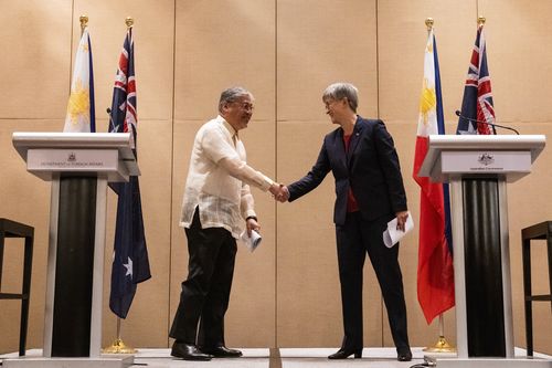 پنی وانگ، وزیر امور خارجه استرالیا، سمت راست، و انریکه مانالو، وزیر امور خارجه فیلیپین، در یک کنفرانس مطبوعاتی مشترک در هتلی در شهر ماکاتی، فیلیپین در روز پنجشنبه 18 مه 2023، با یکدیگر دست می دهند.