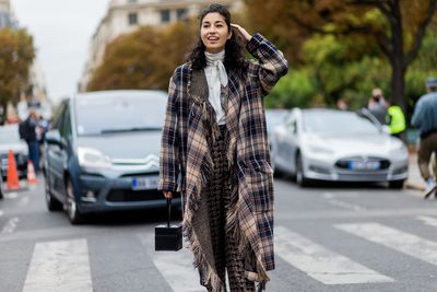 Caroline Issa wearing
a plaid poncho outside Chloe, Paris Fashion Week