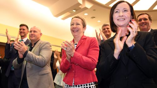 Member for Bulimba Dianne Farmer (centre), Member for Redcliffe Yvette D'Ath (right) and Member for Mulgrave Curtis Pitt (left) give Premier Annastacia Palaszczuk a standing ovation during the first Labor caucus meeting of the 56th Queensland Parliament (AAP)