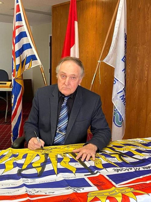 Gary Foster, Mayor of Northern Rockies, a municipality in northeastern British Columbia, Canada, signs the flag