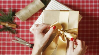 Person wrapping Christmas present.