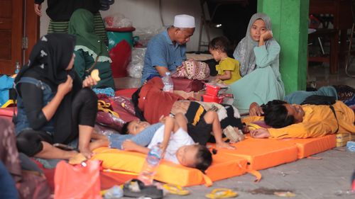 People wait as rescue work is underway after a building under construction collapsed at an Islamic boarding school in Sidoarjo, East Java, Indonesia, Tuesday, Sept. 30, 2025. (AP Photo/Trisnadi)