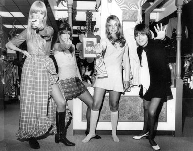 British fashion designer Mary Quant, right, waves as she poses with models, from left, from left, are, Amanda Tear, Rory Davis and Penny Yates, wearing her Mod creations in Little Rock, Ark. on Oct. 25, 1968