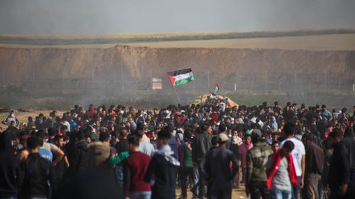 Smoke rises in the air as Palestinian protesters gather for a demonstration near the Gaza-Israel border, on Friday, April 6, 2018. (AAP)