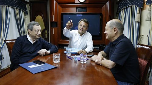 French President Emmanuel Macron, center, German Chancellor Olaf Scholz, right, and Italian Prime Minister Mario Draghi travel on board a train bound to Kyiv.