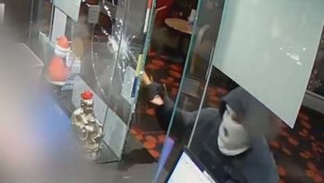 A hooded bandit armed with an axe has been captured on CCTV unleashing against innocent workers at an Adelaide hotel.