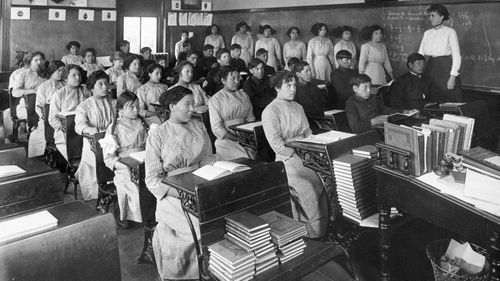 In this undated photo provided by National Archives, fourth grade students sit in a classroom at the former Genoa Indian Industrial School in Genoa, Nebraska, USA.