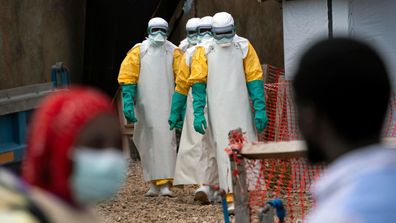Health workers wearing protective gear begin their shift at an Ebola treatment center in Beni, Congo. 
