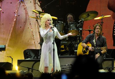 Dolly Parton and Kieth Urban perform onstage at the 2010 We're All For The Hall benefit concert at the Bridgestone Arena on October 5, 2010 in Nashville, Tennessee.