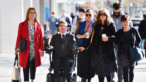 Jonathon Hawtin (second left) is seen outside the District court in Adelaide, Tuesday, August 6, 2019.