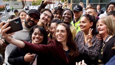 Jacinda Ardern taking a selfie with staff and students from Massey University.