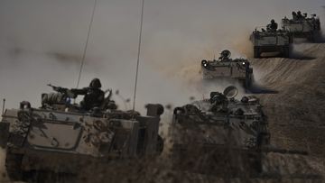 Israeli APCs head toward the Gaza Strip border in southern Israel on Friday, Oct.13, 2023. (AP Photo/Ariel Schalit)
