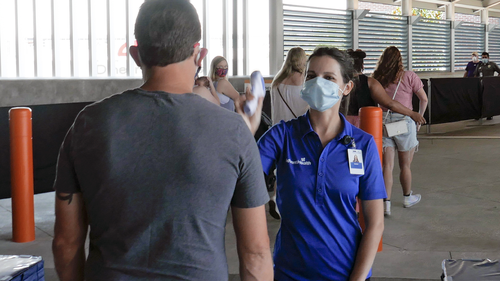 Because of the coronavirus pandemic, a guest goes through a temperature check before entering the Disney Springs shopping, dining and entertainment complex Tuesday, June 16, 2020, in Lake Buena Vista, Fla. (AP Photo/John Raoux)