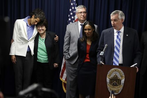District Attorney Kevin Steele, right, speaks at a news conference as accuser Andrea Constand, left, embraces her attorney Dolores Troiani after Bill Cosby was found guilty in his sexual assault trial.