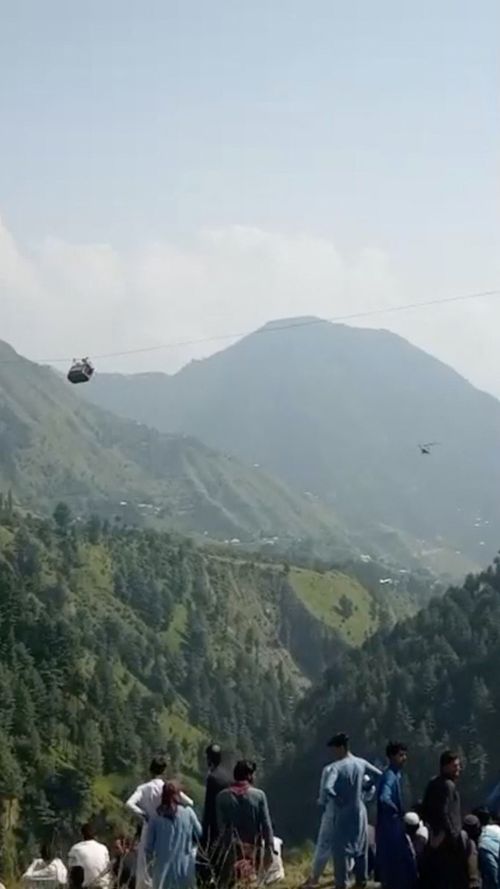 A view shows a helicopter carrying rescue operation next to the cable car with students stranded mid-air in Battagram, Pakistan, August 22, 2023, in this screen grab obtained from social media video.  