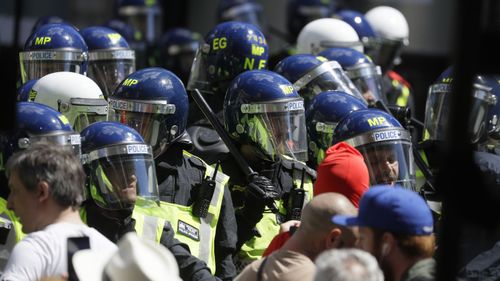 British police officers in riot gear scuffle with members of far-right groups protesting against a Black Lives Matter demonstration, in central London, Saturday, June 13, 2020.