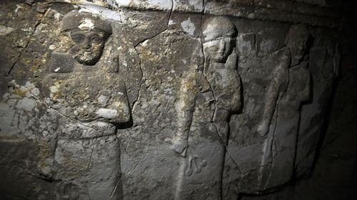 A relief showing three women facing forward.