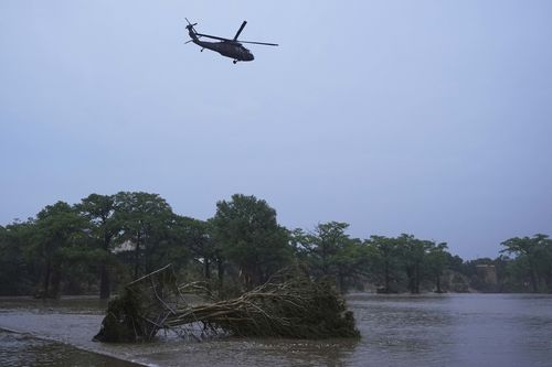 A helicopter flies over the Guadalupe River after a flash flood swept through the area, in Kerrville, Texas.
