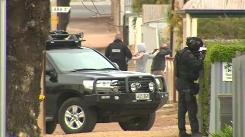 Earlier today, multiple residents in Wallaroo were led from their homes at gunpoint by heavily armed police as the search continued. Picture: 9NEWS