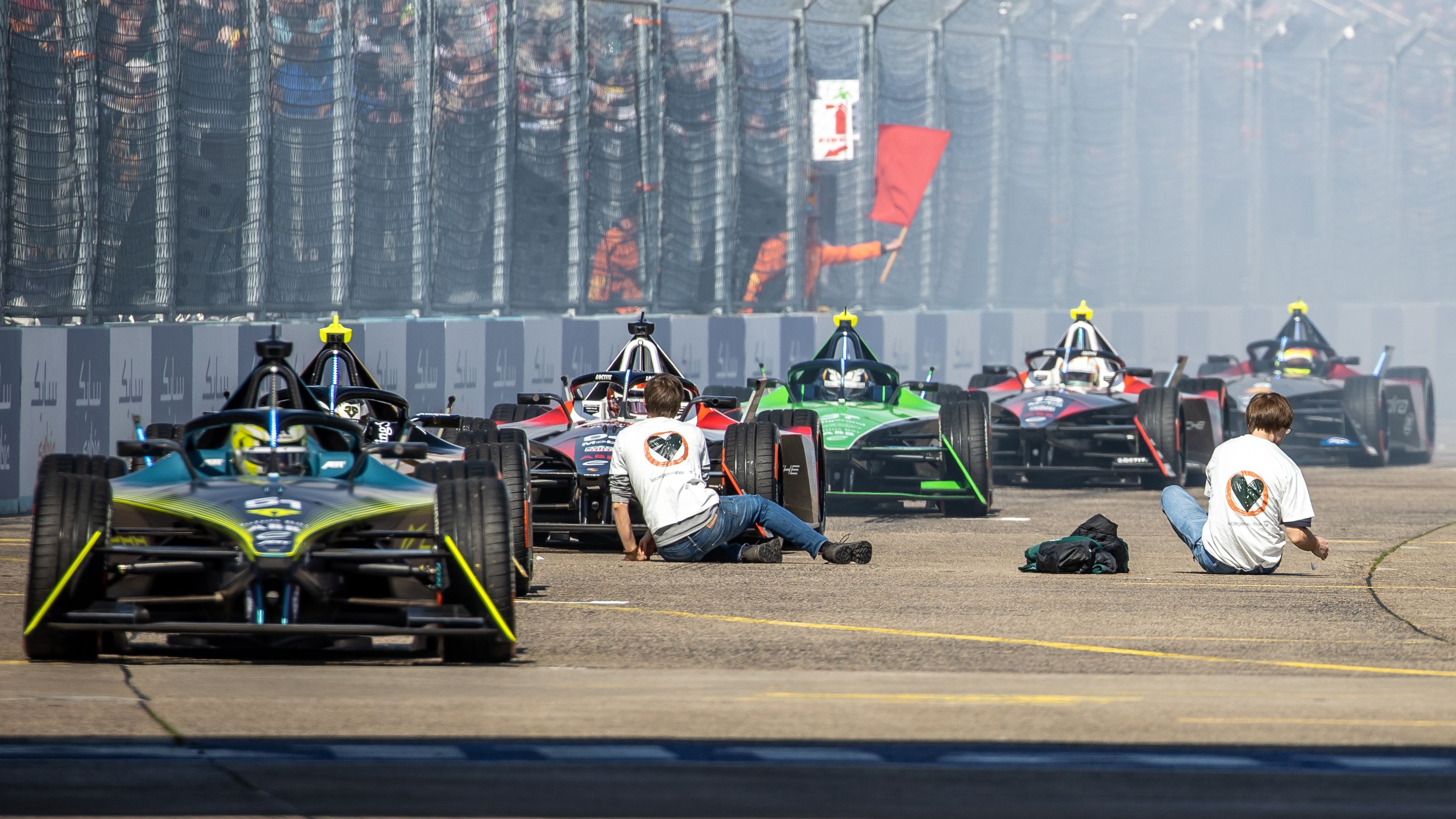 Last generation climate activists sit on the track in front of the Formula E race cars ready to start. Photo: Andreas Gora/dpa (Photo by Andreas Gora/picture alliance via Getty Images)