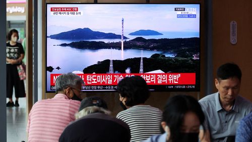 Passengers watch a TV broadcasting a news report on North Korea firing a space rocket, at a railway station in Seoul, South Korea.
