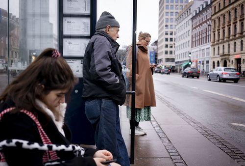 Passengers at a bus stop in Copenhagen, Denmark, Tuesday, February 1, 2022. 