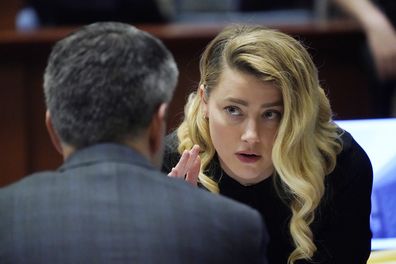 Actress Amber Heard talks to her attorney in the courtroom at the Fairfax County Circuit Court in Fairfax, Va., Monday April 18, 2022. Actor Johnny Depp sued his ex-wife Amber Heard for libel in Fairfax County Circuit Court after she wrote an op-ed piece in The Washington Post in 2018 referring to herself as a "public figure representing domestic abuse." (AP Photo/Steve Helber, Pool)