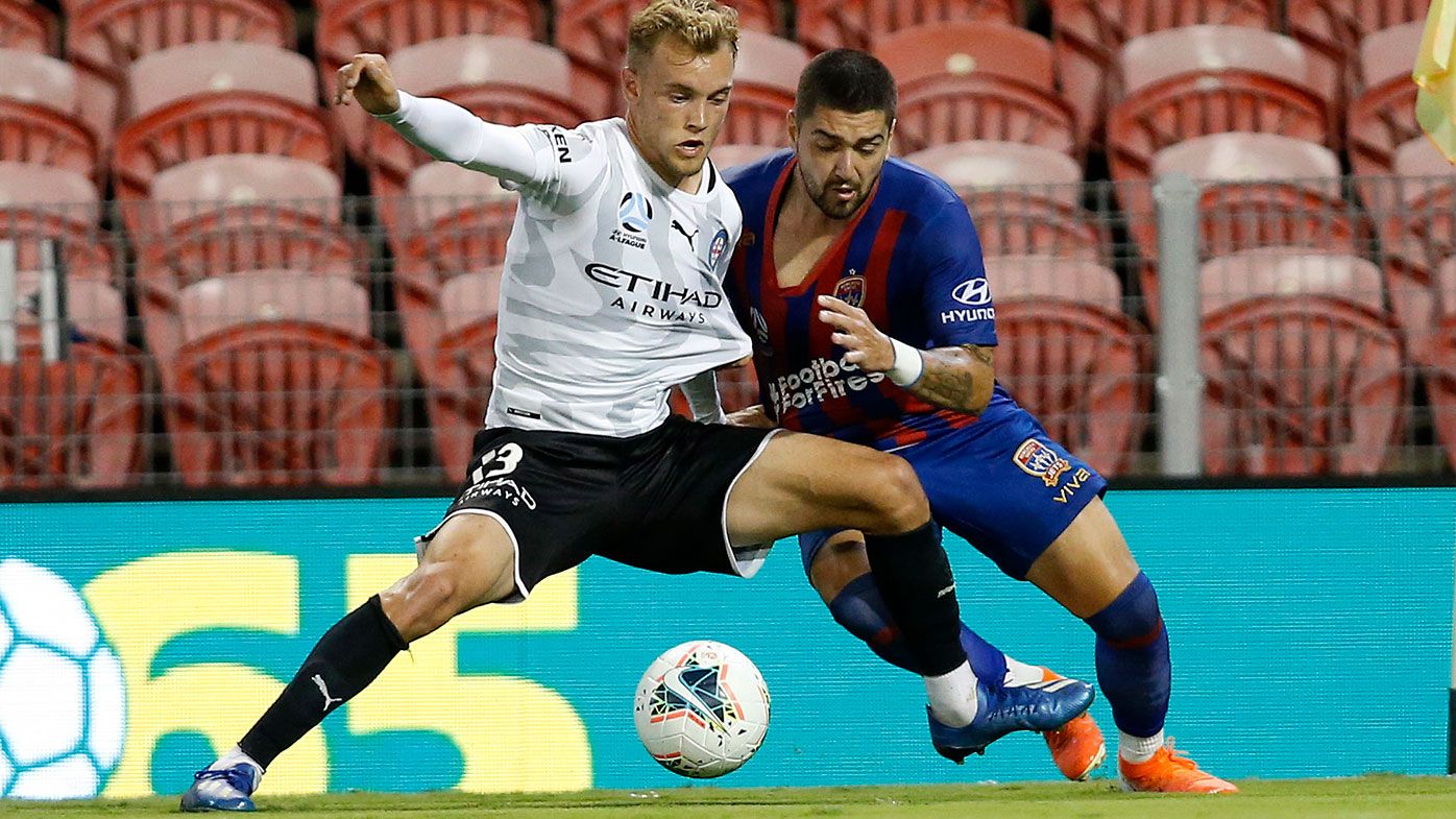 Dimi Petratos of the Newcastle Jets competes for possession with Nathaniel Atkinson of Melbourne City.