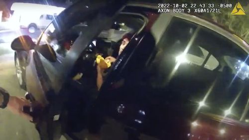 In this image taken from Oct. 2, 2022 police body camera video and released by San Antonio Police Department, Erik Cantu looks toward San Antonio Police officer James Brennand while holding a hamburger in a fast food restaurant parking lot as the officer opens the car door in San Antonio, Texas. Brennand opened fire several times wounding the unarmed teenager as he drove away. 