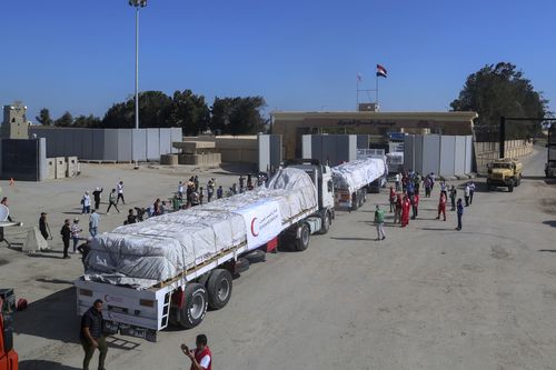 Trucks of Egyptian Red Crecent carrying humanitarian aid for the Gaza Strip cross the Rafah border gate, in Rafah, Egypt, Saturday, Oct. 21, 2023. 