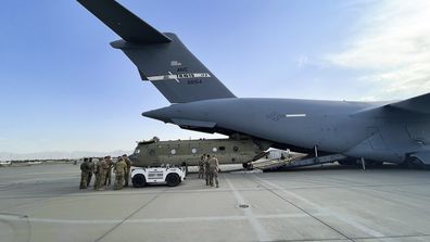 In this image provided by the Department of Defense, a CH-47 Chinook from the 82nd Combat Aviation Brigade, 82nd Airborne Division is loaded onto a U.S. Air Force C-17 Globemaster III at Hamid Karzai International Airport in Kabul, Afghanistan, Saturday, Aug, 28, 2021. (Department of Defense via AP)
