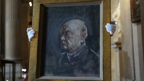 A member of staff from Sotheby's poses for the media with a portrait of the iconic former British Prime Minister Winston Churchill, painted by Graham Sutherland in 1954, at Blenheim Palace, Woodstock, England, Tuesday, April 16, 2024.