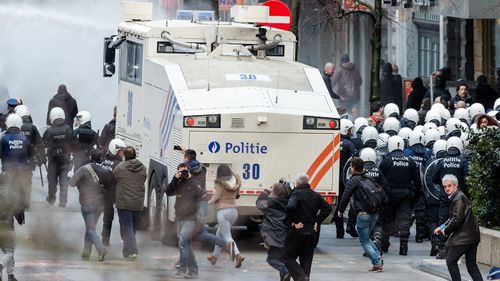 Police use a water canon as right wing demonstrators protest at a memorial site at the Place de la Bourse in Brussels, (AAP)