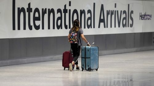 A passenger arrives from a flight at Terminal 5 of Heathrow Airport in London, Monday, August 2, 2021. 