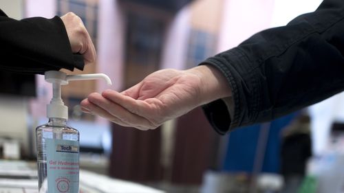 A man washes his hands during the first round of the municipal elections, in Lille, northern France, Sunday March 15, 2020. 